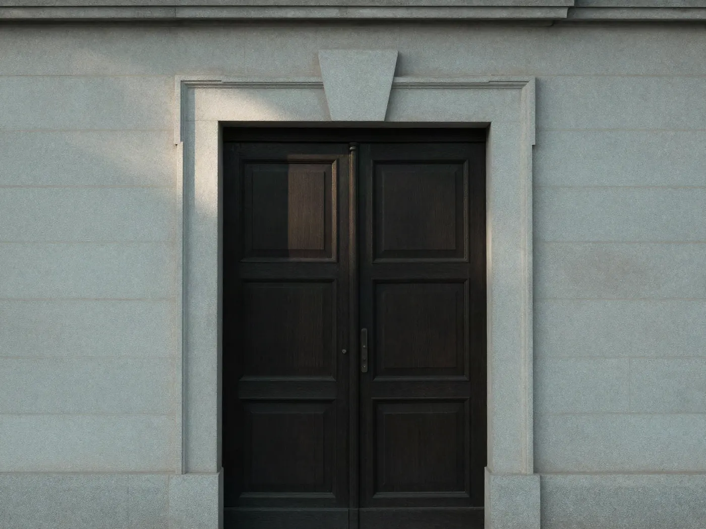 Puerta de madera oscura del edificio donde funciona el estudio, con luz de la mañana.